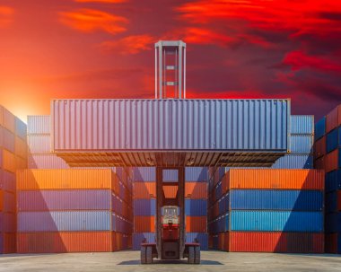 Forklift kamyon kargo Konteyner Taşımacılık ithalat, ihracat ve renkli günbatımı gökyüzü arka plan için nakliye bahçesinde kaldırma 