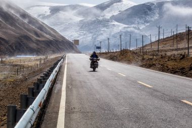 Motorcu motosiklet güzel yolda kış Tibet altında kar dağ, Sichuan, Çin