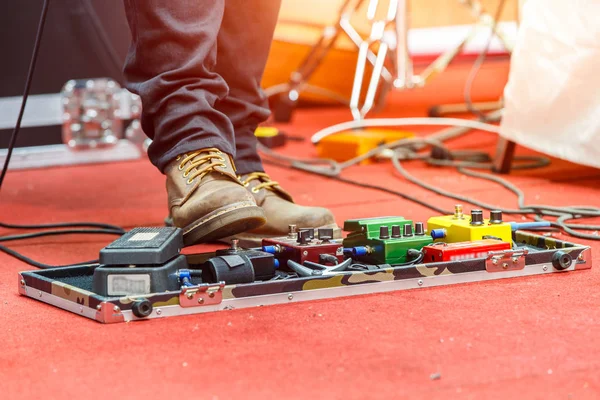 Feet of guitar player on a stage with set of distortion effect pedals. Selective focus — Stock Photo, Image