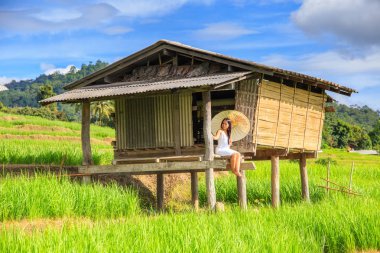 Asyalı kadın Teras pirinç çiftlik kırsal kökenli Pa Pong Pieng Köyü, Mae Chaem, Chiang Mai, Tayland oturan geleneksel kostüm giymek