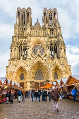 REIMS, FRANCE, NOVEMBER 23, 2016 : View of the facade of the cathedrale of reims and walking street Christmas festival, november 23, 2016, in Reims, Champagne, France. clipart