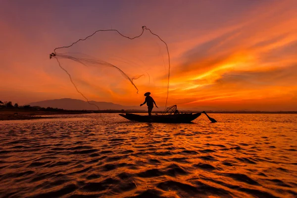 Σιλουέτα ψαράς με δίχτυ στην λίμνη στην Ταϊλάνδη — Φωτογραφία Αρχείου