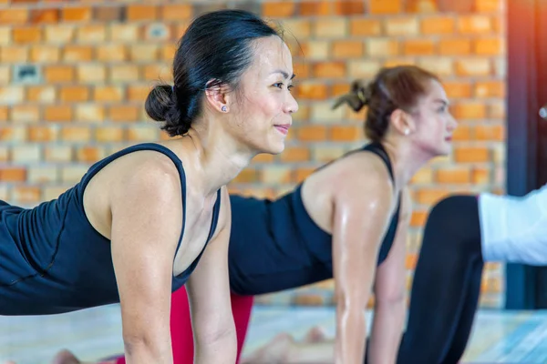 Gimnasio grupo femenino asiático haciendo namaste yoga pose en fila en la clase de yoga. enfoque selectivo — Foto de Stock