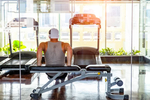 Young man in sportswear push-up on board at inside of gym — Stock Photo, Image