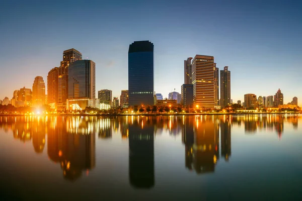 市中心在日出与反射在湖，曼谷，泰国曼谷市 — 图库照片