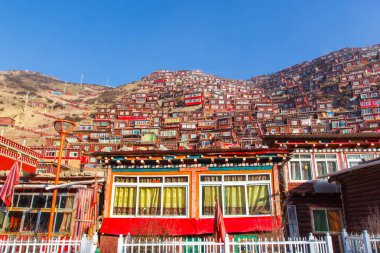 Red monastery and home at Larung gar (Buddhist Academy) in sunshine day and background is blue sky, Sichuan, China clipart