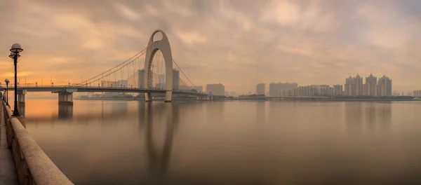 珠江川と中国広州市の金融街のモダンな建物に近代的な橋 — ストック写真