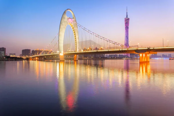 Espectáculo de luz en la hora de la puesta del sol en el puente moderno en el río Zhujiang y el edificio moderno del distrito financiero en la ciudad de Guangzhou, China —  Fotos de Stock