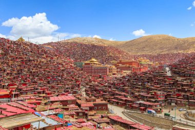 Kırmızı Manastırı ve güneşli gün ve arka plan Larung gar (Budist Akademisi) evde olduğunu mavi gökyüzü, Sichuan, Çin