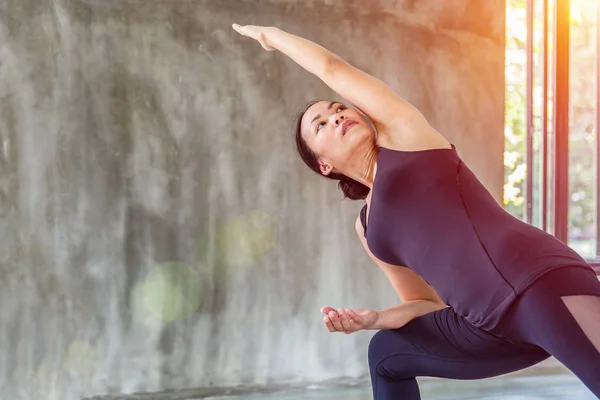 Asian trainee strong woman practicing difficult yoga pose in a concrete background — Stock Photo, Image