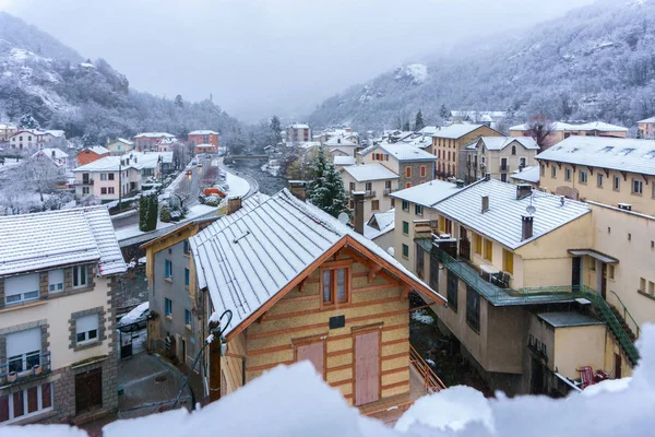 Apartments and hotel of French mountain ski resort in falling snow day, Ax-les-Thermes, France
