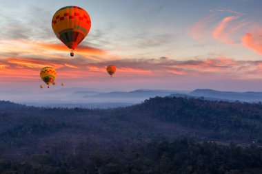 Colorful hot air balloons flying over mountain at Pakse, Laos clipart