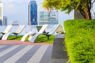 Kat mülkiyeti çatı bahçesi köşede Singapur Finans bölgesine ve arka bina iş peyzaj üzerinde sandalye ile rahatla