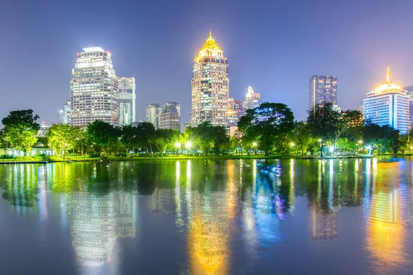 Відображення ділового району будівля з парку з нічна сцена з Лумпіні парку, Бангкок, Таїланд — стокове фото