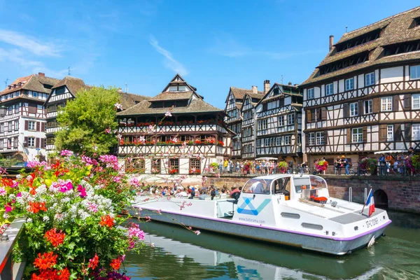 STRASBOURG, FRANCE - JUL 18, 2017: Traditional colorful houses in La Petite, with tourists taking a boat ride along traditional colorful houses on idyllic river Lauch in summer, Colmar, Alsace, France — Stock Photo, Image
