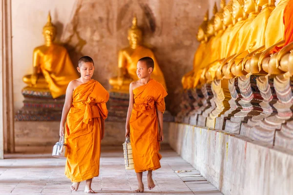 Mnich dwóch nowicjuszy chodzenia i mówienia w starej Świątyni w czasie zachód prowincji Ayutthaya, Tajlandia — Zdjęcie stockowe