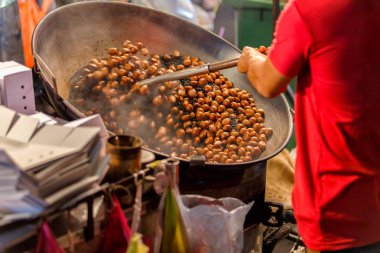 Kestane sokak chinatown veya Yaowarat Road Bangkok, Tayland kavurma bir adam işçi hareketi el kadar kapatın