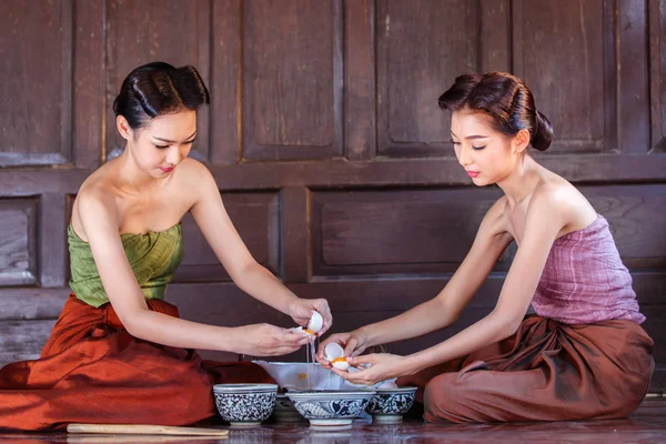 Porträt junge Asiatinnen in alten thailändischen Gewändern helfen dabei, das Dessert thailändisch der thailändischen Kultur zu machen — Stockfoto