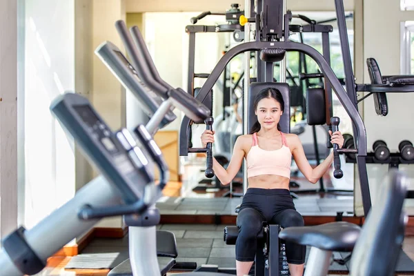 Portrait of beautiful asian female making exercise with strength at the gym — Stock Photo, Image