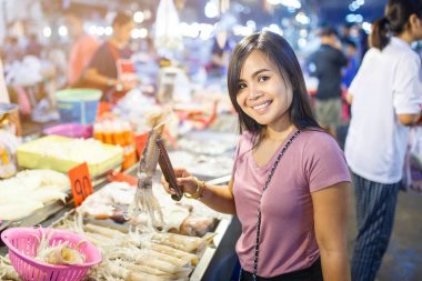 Genç Asyalı kadın kalamar buz yerel pazar ahır ile taze deniz ürünleri, Bangkok, Tayland için alışveriş