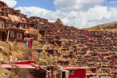 Kırmızı Manastırı ve güneşli gün ve arka plan Larung gar (Budist Akademisi) evde olduğunu mavi gökyüzü, Sichuan, Çin.