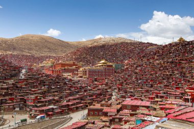 Kırmızı Manastırı ve güneşli gün ve arka plan Larung gar (Budist Akademisi) evde olduğunu mavi gökyüzü, Sichuan, Çin.
