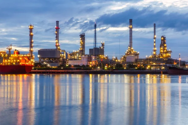 Petrol rafineri tesisi sonra yağmur gökyüzü arka plan ile alacakaranlıkta.