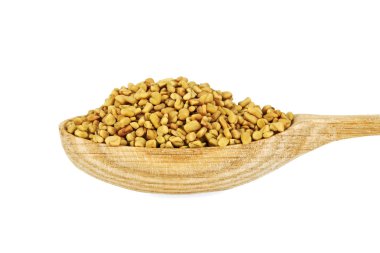 Fenugreek seeds in wooden spoon isolated on white background clipart