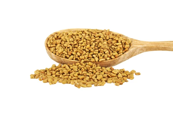 Fenugreek seeds in wooden spoon isolated on white background — Stock Photo, Image