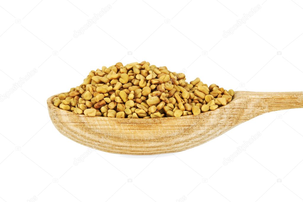 Fenugreek seeds in wooden spoon isolated on white background