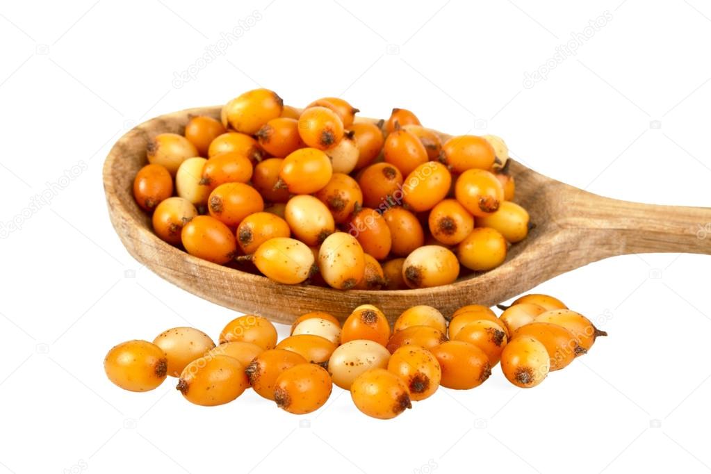 Sea buckthorn berries in wooden spoon on a white background