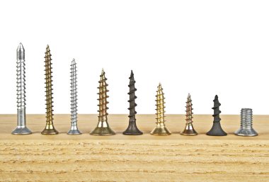 Beyaz bir arka plan üzerinde ahşap tahta üzerinde çeşitli vida