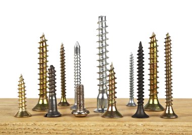 Beyaz bir arka plan üzerinde ahşap tahta üzerinde çeşitli vida