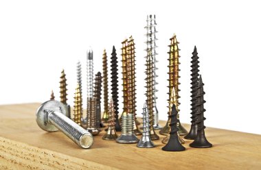 Beyaz bir arka plan üzerinde ahşap tahta üzerinde çeşitli vida