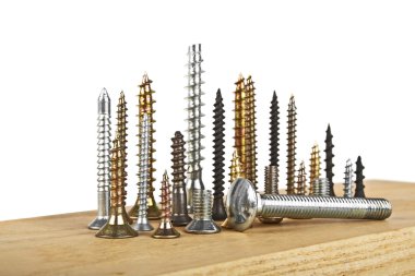 Beyaz bir arka plan üzerinde ahşap tahta üzerinde çeşitli vida