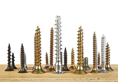 Beyaz bir arka plan üzerinde ahşap tahta üzerinde çeşitli vida