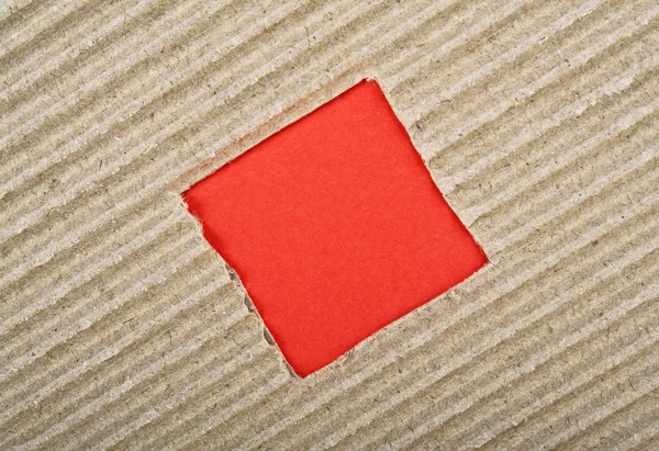 Čtvercový otvor s červeným papírem v kartonu — Stock fotografie