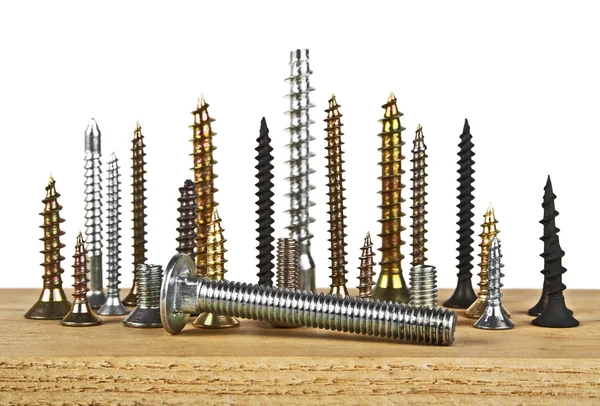 Beyaz bir arka plan üzerinde ahşap tahta üzerinde çeşitli vida