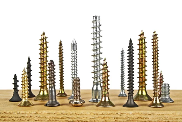 Beyaz bir arka plan üzerinde ahşap tahta üzerinde çeşitli vida