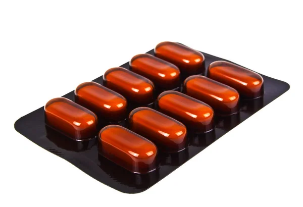 Blister av brunt piller på vit bakgrund — Stockfoto