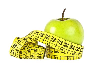 Beyaz zemin üzerinde mezura olan yeşil elma