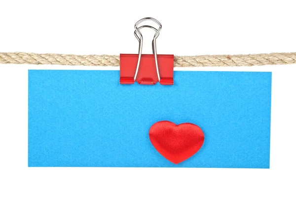 Etiqueta azul con corazón rojo sobre una cuerda aislada sobre fondo blanco — Foto de Stock