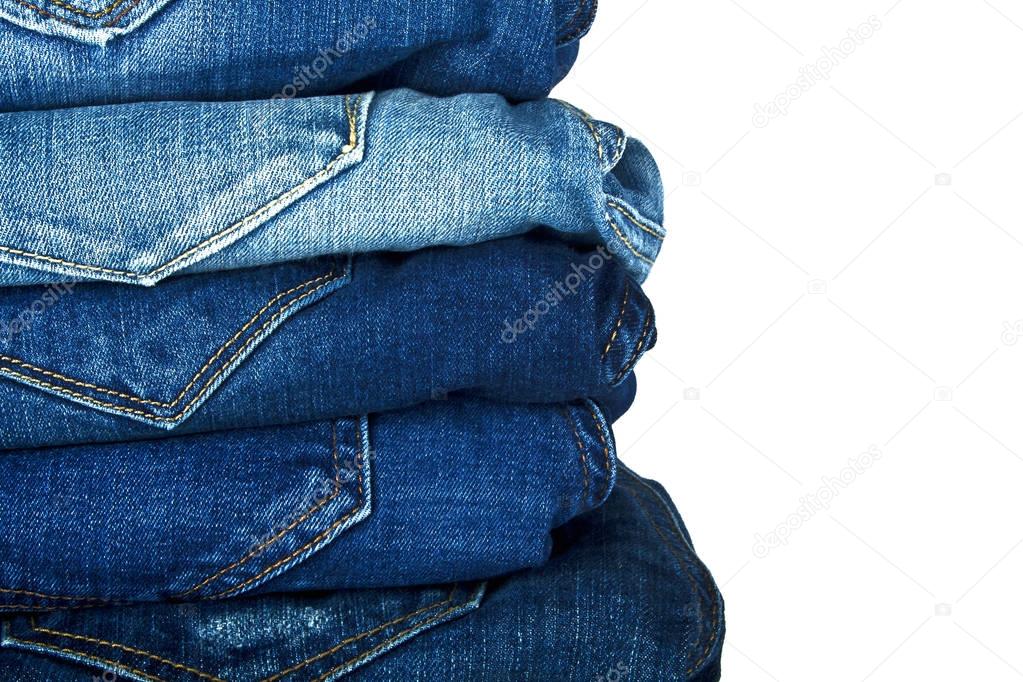 Lot of different blue jeans isolated on white background