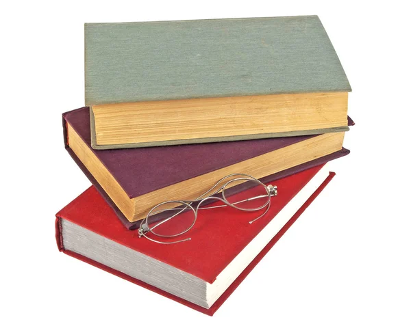 一叠旧书籍和孤立的白色背景上的旧眼镜 — 图库照片