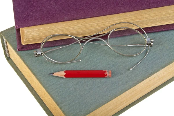 Alte Bücher, roter Bleistift und alte Brille isoliert auf weißem Hintergrund — Stockfoto