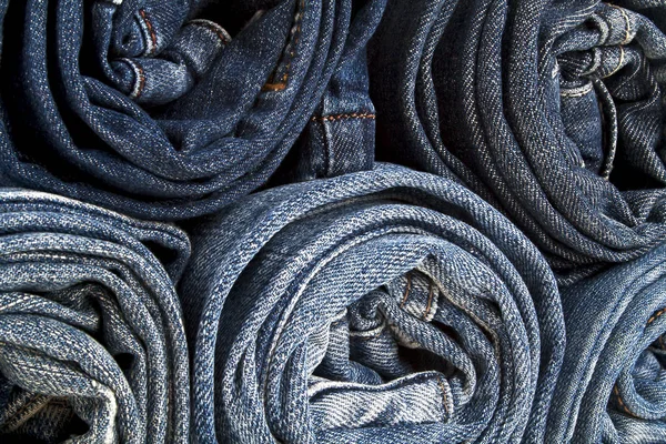 Sfondo di una pila ha fatto rotolare jeans — Foto Stock