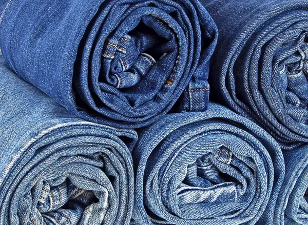 Fundo de uma pilha de calças de ganga enroladas — Fotografia de Stock