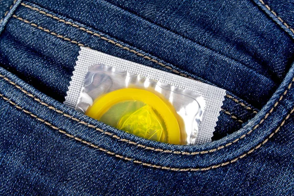 Кольоровий презерватив у синій кишені джинсів — стокове фото
