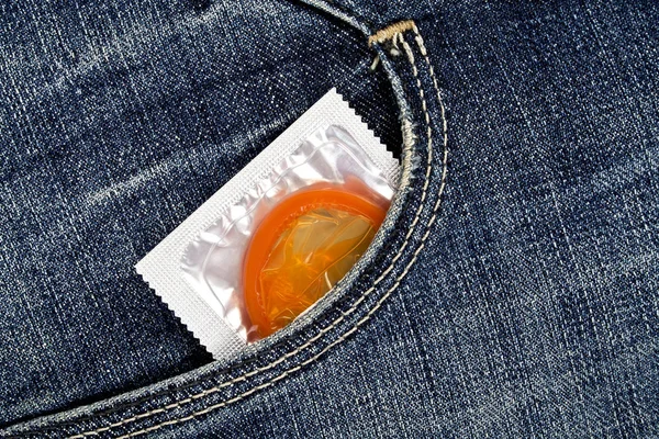 Кольоровий презерватив у синій кишені джинсів — стокове фото