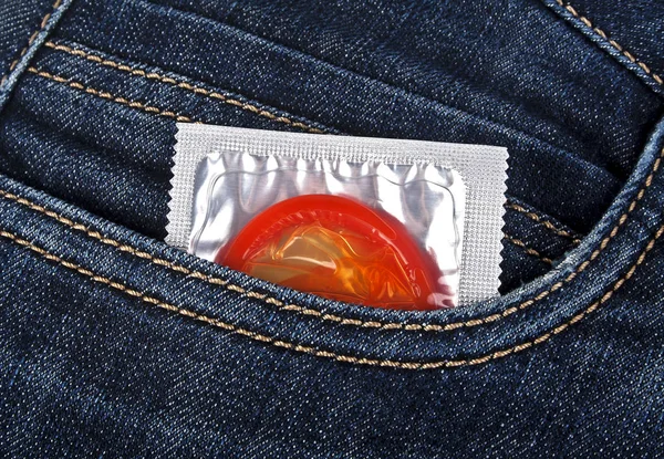 Farbiges Kondom in einer blauen Jeanstasche — Stockfoto